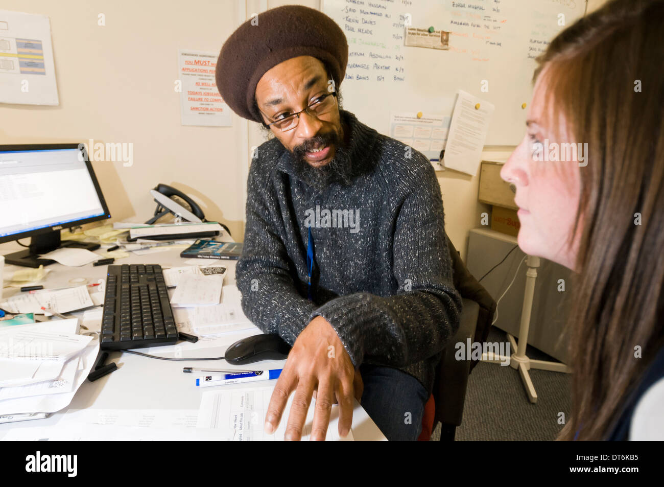 Deux personnes assis à un bureau dans un bureau ayant une discussion Banque D'Images