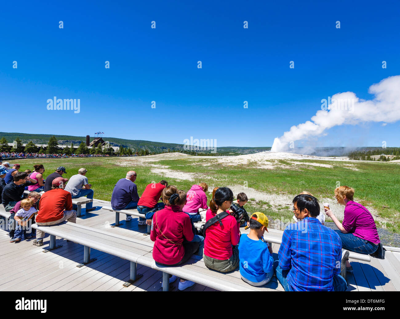 Les touristes à Old Faithful Geyser Old Faithful Inn avec derrière, Upper Geyser Basin, Parc National de Yellowstone, Wyoming, USA Banque D'Images