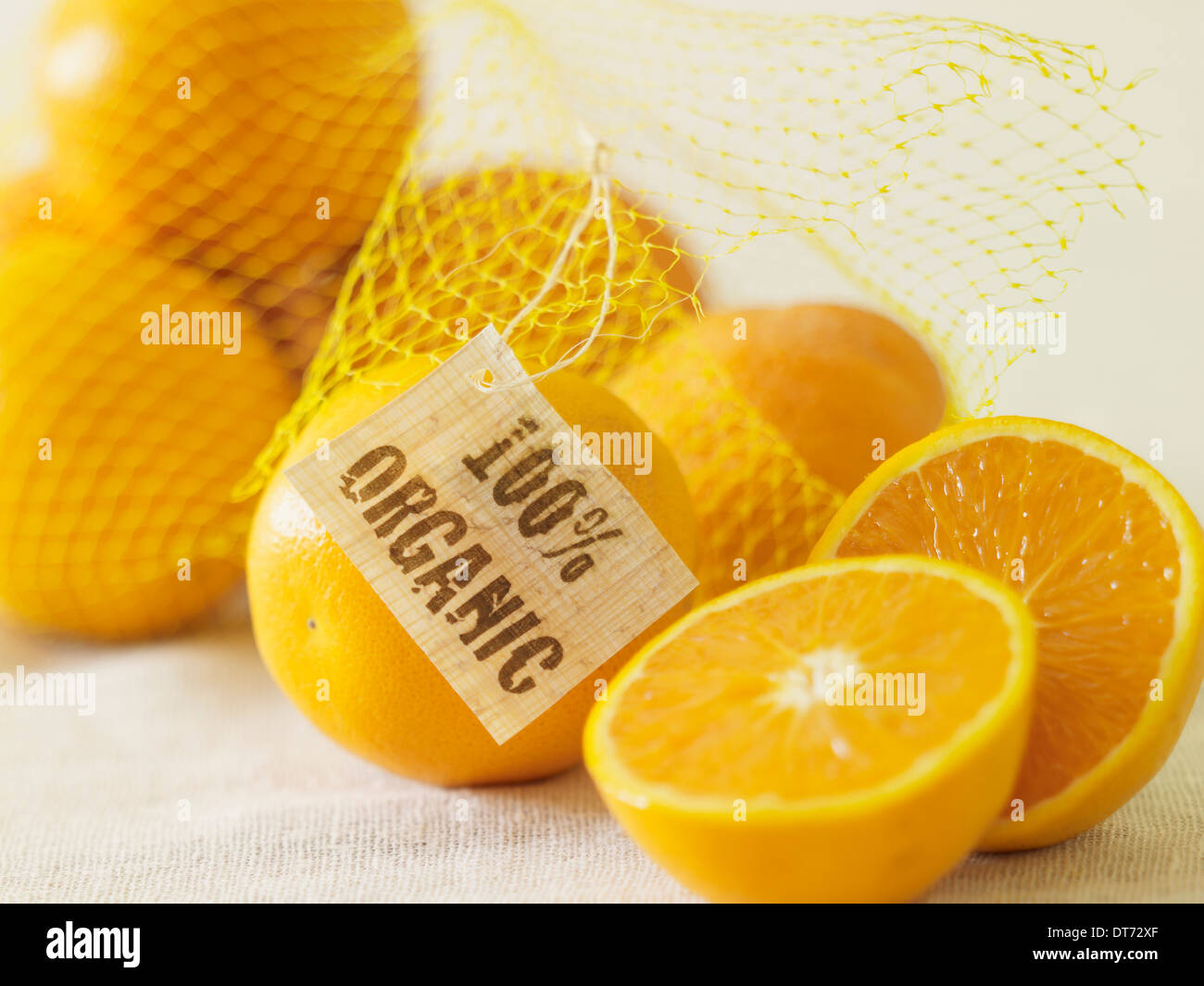 Un sac d'oranges organiques sur une surface de tissu beige. Banque D'Images