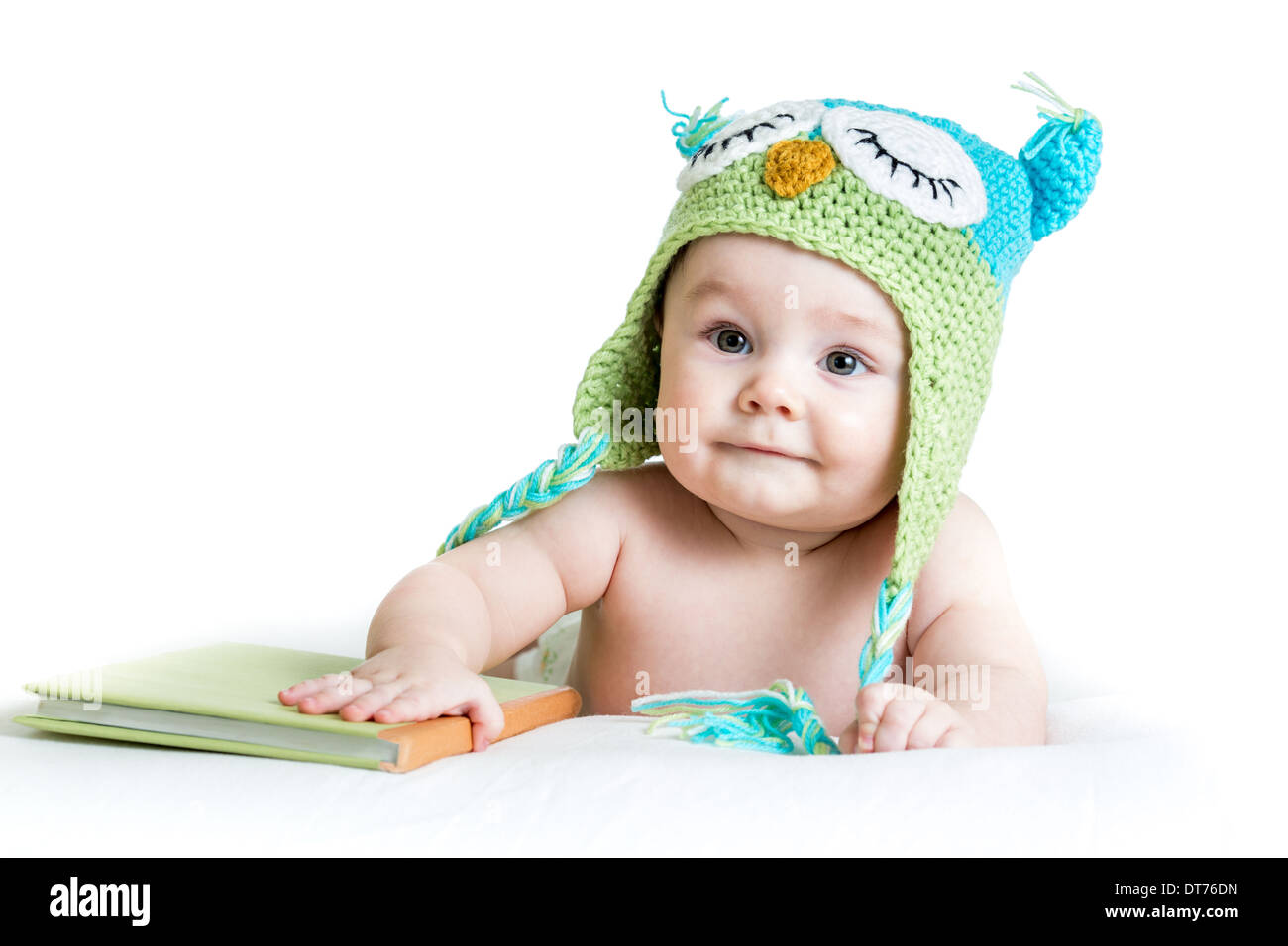 Bébé dans funny owl owl hat tricoté avec livre sur fond blanc Banque D'Images