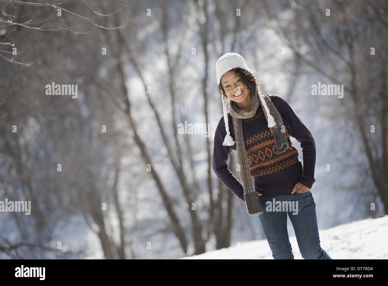 Paysage d'hiver avec de la neige au sol. Une jeune femme portant un chapeau laineux. Banque D'Images