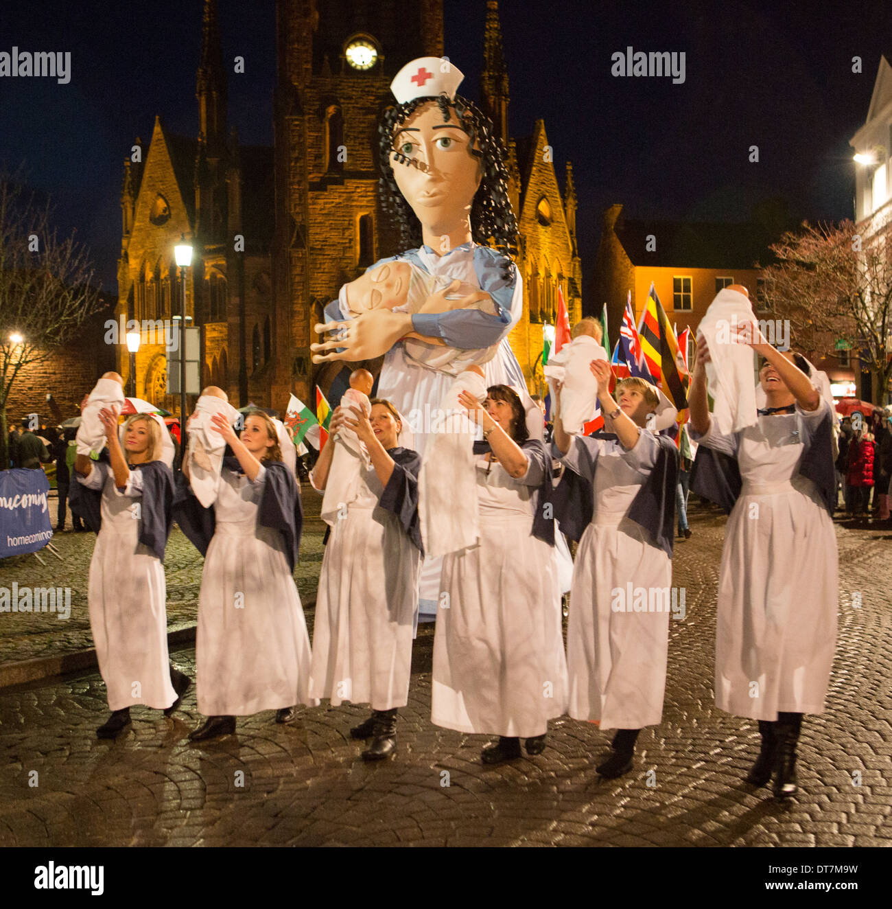 Homecoming Carnival rues de Dumfries femmes habillées comme sages-femmes portant des bébés avec grande marionnette de midwive derrière l'Ecosse Banque D'Images