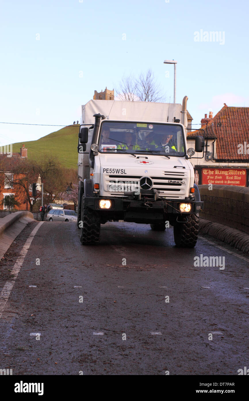 Burrowbridge, Somerset, Royaume-Uni - 11 février 2014. La Britsh Croix rouge, continuer à fournir des secours sur les niveaux de Somerset, le véhicule Unimog est montré ici de traverser le pont à Burrowbridge. L'Unimog est équipé d'un tuba tuyau d'échappement pour conduire à travers l'eau d'inondation. Banque D'Images