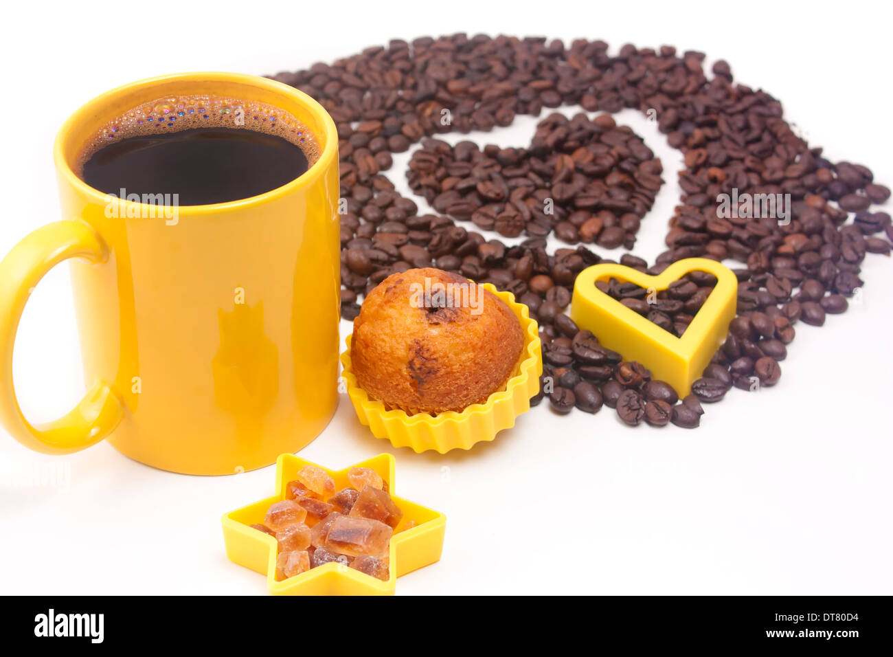 Tasse de café, certains sucre brun, muffin et un café coeur en arrière-plan sur fond blanc Banque D'Images