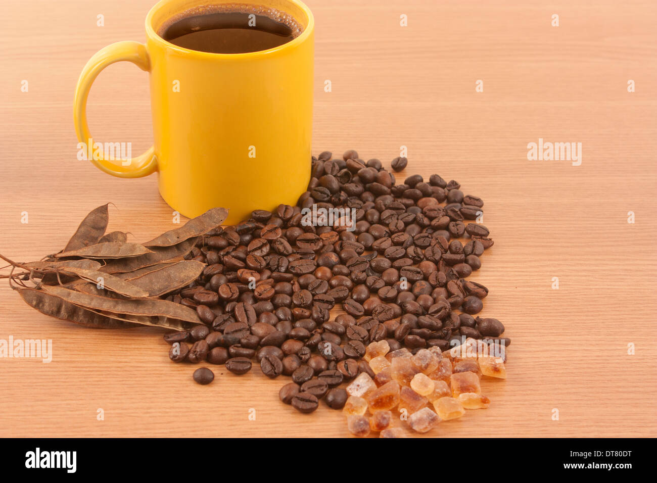 Tasse de café, quelques grains de café et de sucre brun sur fond de bois Banque D'Images
