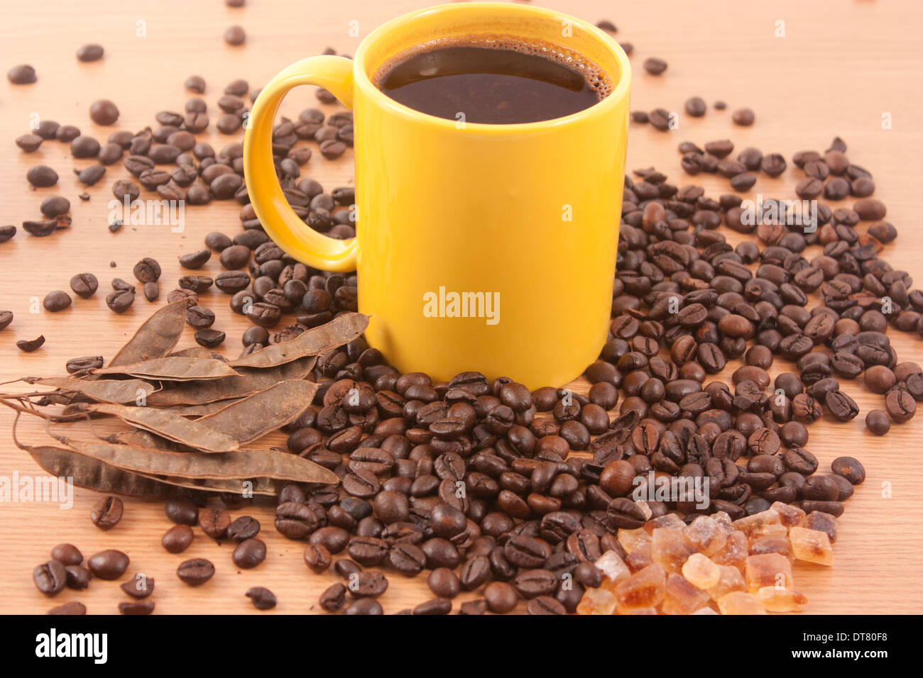 Tasse de café, quelques grains de café et de sucre brun sur fond de bois Banque D'Images