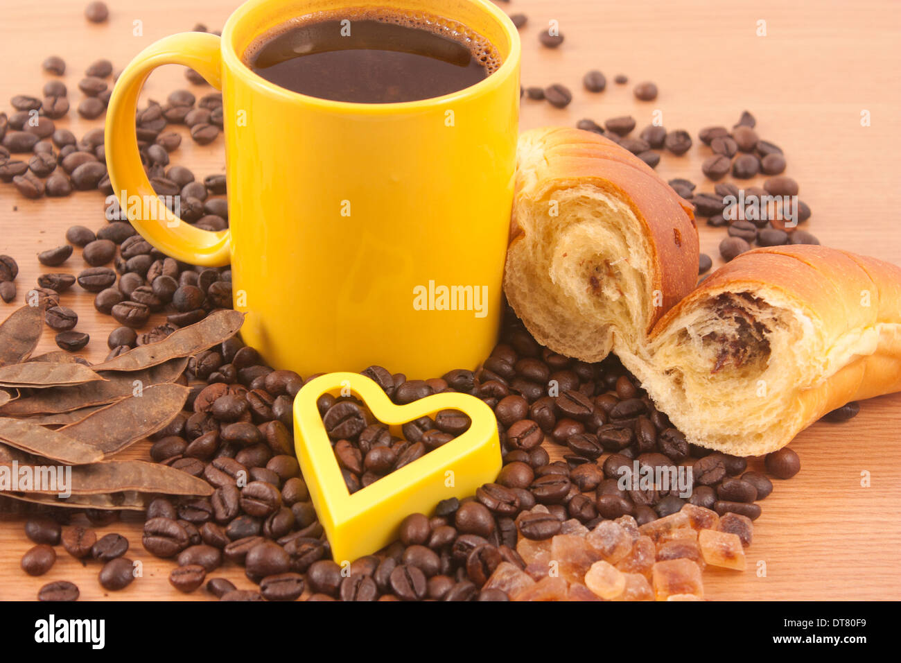 Tasse de café, le sucre brun, les grains de café et un croissant sur fond de bois Banque D'Images