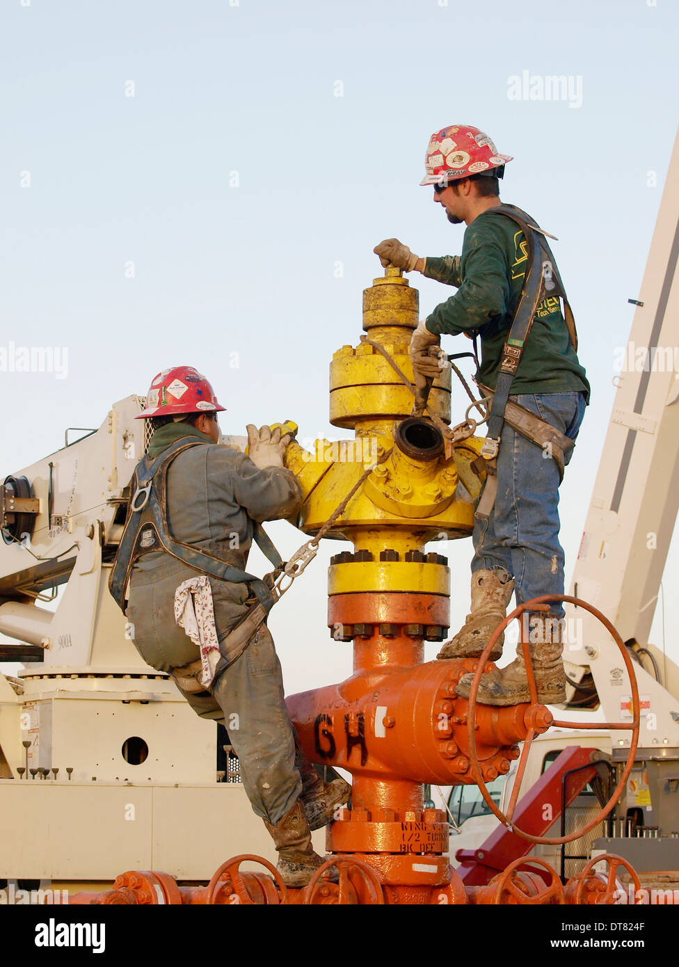 Roughnecks position sur la tête de puits et d'attendre à raccorder des tuyaux pour forcer l'eau dans l'huile bien tandget et gaz. Banque D'Images