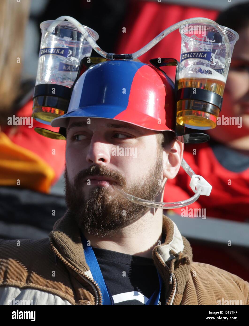 Sochi, Russie. 12 février 2014. Un Spectateur porte un casque potable avec  deux tasses de bière au cours de l'épreuve individuelle de combiné nordique  (petit tremplin/ 10 km) dans la région de