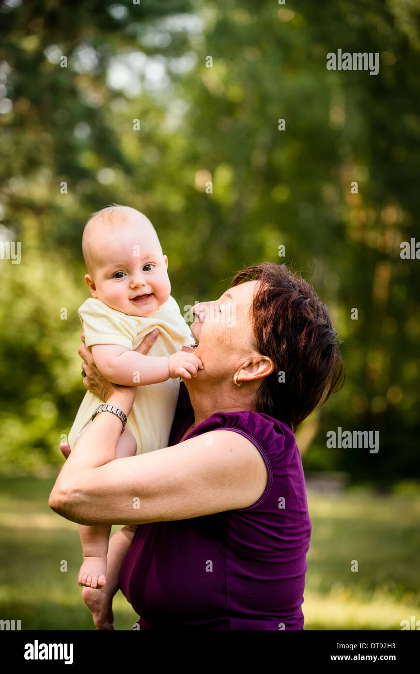 Grand-mère avec ses petits-enfants - senior woman holding sa petite-fille dans la nature en plein air Banque D'Images