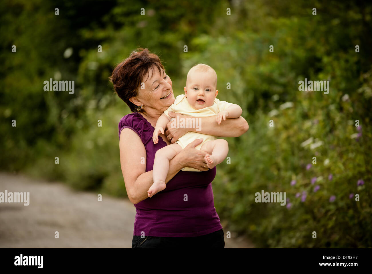 Grand-mère avec ses petits-enfants - senior woman holding sa petite-fille dans la nature en plein air Banque D'Images