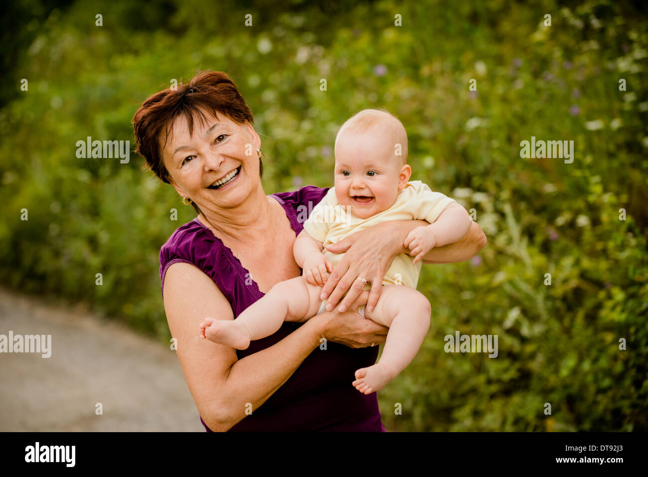 Grand-mère avec ses petits-enfants - senior woman holding sa petite-fille dans la nature en plein air Banque D'Images