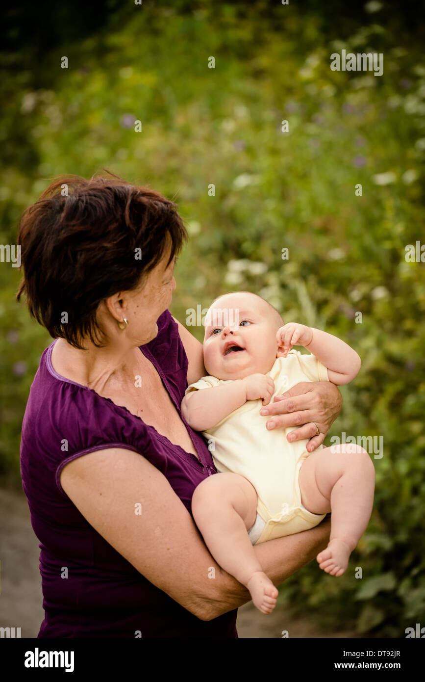 Grand-mère avec ses petits-enfants - senior woman holding sa petite-fille dans la nature en plein air Banque D'Images