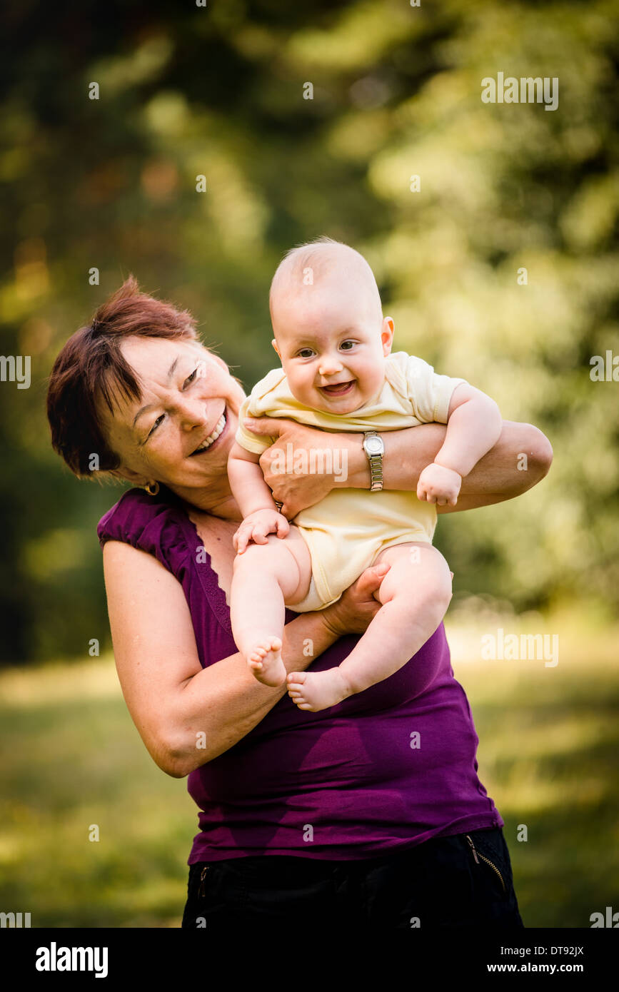 Grand-mère avec ses petits-enfants - senior woman holding sa petite-fille dans la nature en plein air Banque D'Images