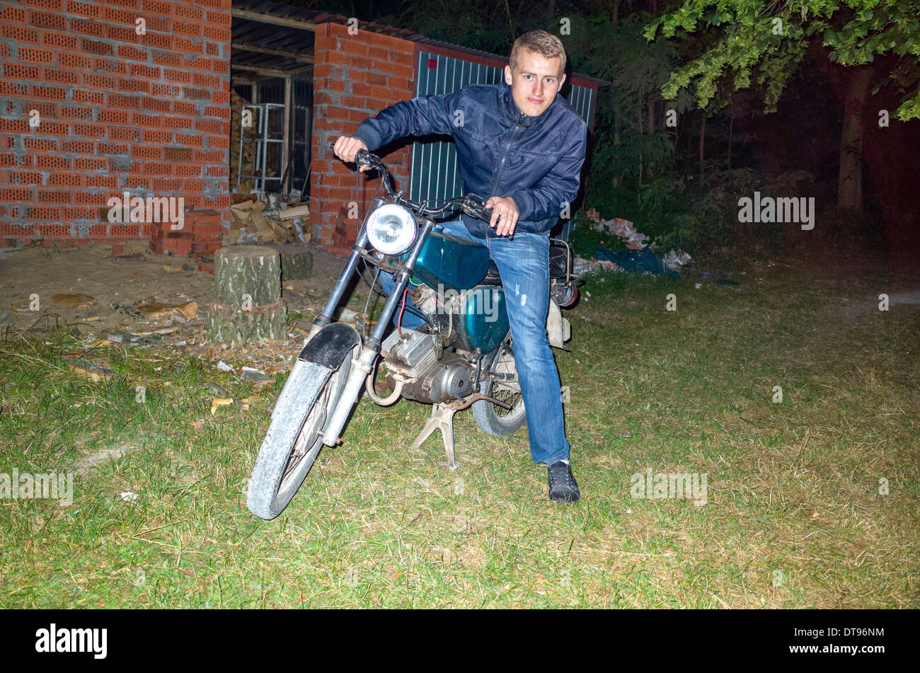 L'âge des adolescents polonais heureux Cool 18 assis sur sa moto dans la nuit. Zawady Centre de la Pologne Banque D'Images