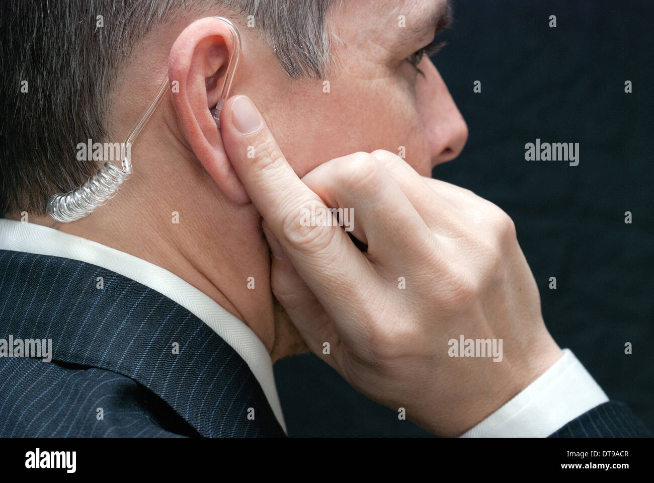 Close-up d'un agent des services secrets à l'écoute de son écouteur, près côté. Banque D'Images