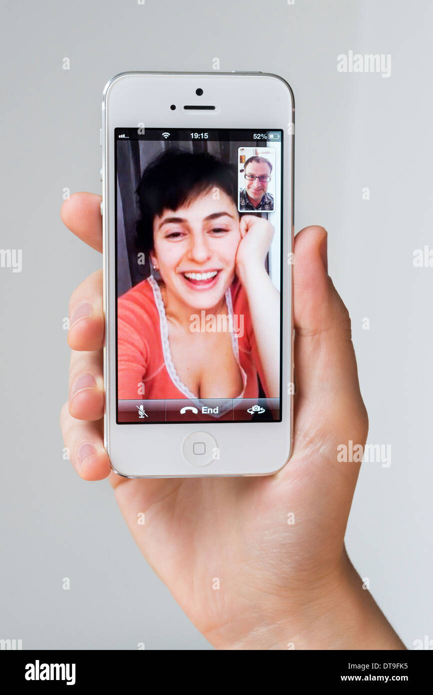 Jeune femme parlant via FaceTime sur iPhone Apple blanc, UK Banque D'Images