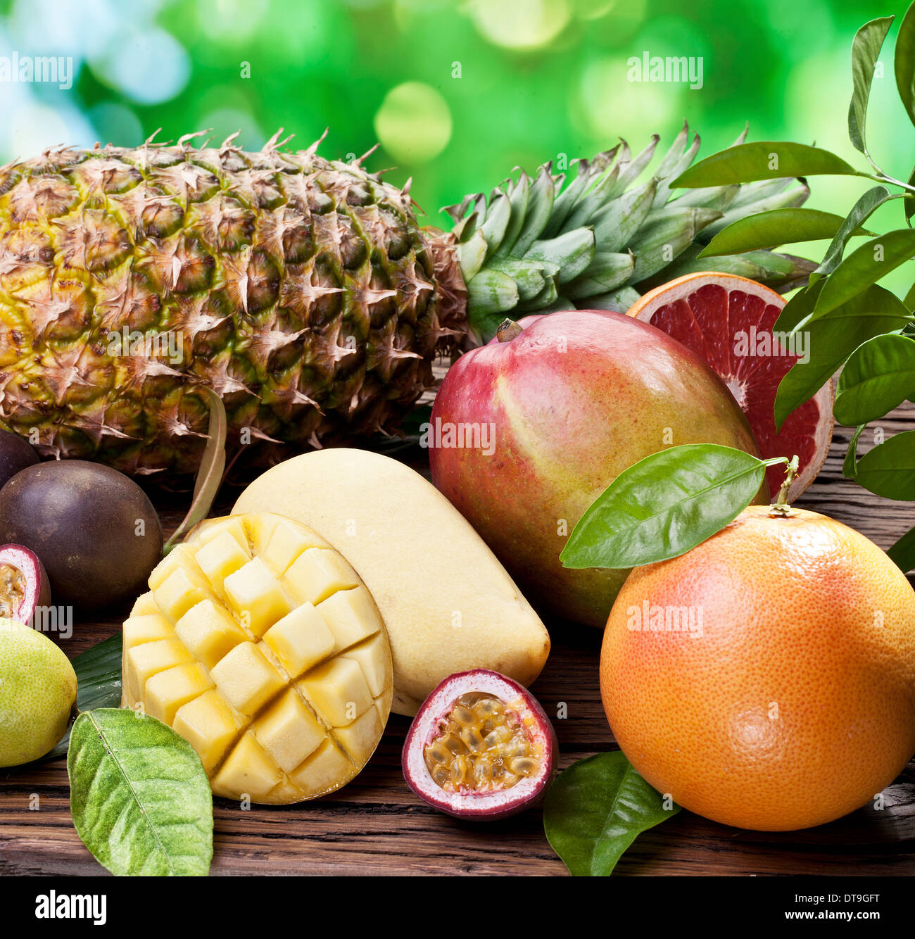 Fruits exotiques sur une table en bois avec feuillage vert sur l'arrière-plan. Banque D'Images