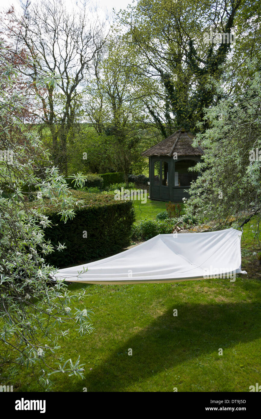UK gardens. Jardin contemporain hamac entre deux arbres. Banque D'Images