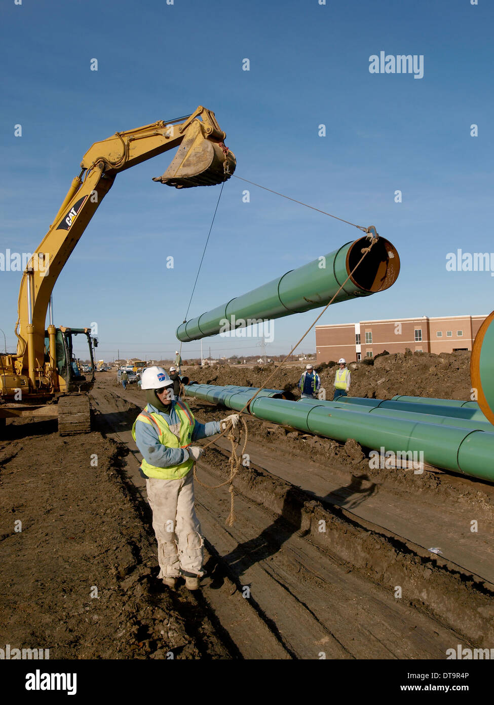 Workman se déplace en position d'obtenir des tuyaux soudés ensemble pour un pipeline pour acheminer le gaz naturel vers les marchés. Banque D'Images