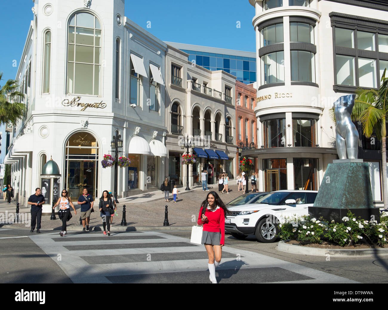 Jeune femme crossing Rodeo Drive à Beverly Hills, Los Angeles, USA Banque D'Images
