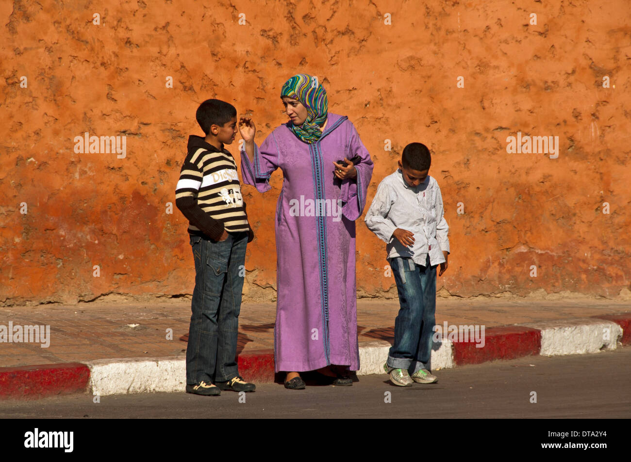 Mère en costume traditionnel avec foulard et djellaba, avec ses deux fils dans les vêtements occidentaux, Médine ou centre historique Banque D'Images