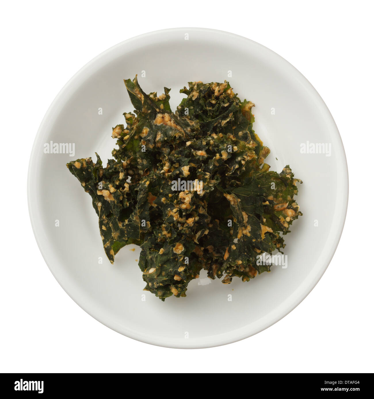 Kale chips rôties dans un bol isolé sur fond blanc Banque D'Images
