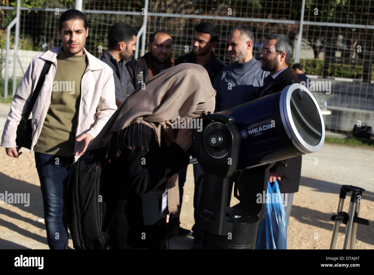 La ville de Gaza, bande de Gaza, territoire palestinien. Feb 13, 2014. Un étudiant palestinien regarde à travers un télescope vers le soleil au cours d'une formation pratique pour identifier l'astronome de taches de couleur et son impact, dans la ville de Gaza le 13 février 2014 Credit : Ashraf Amra/APA Images/ZUMAPRESS.com/Alamy Live News Banque D'Images