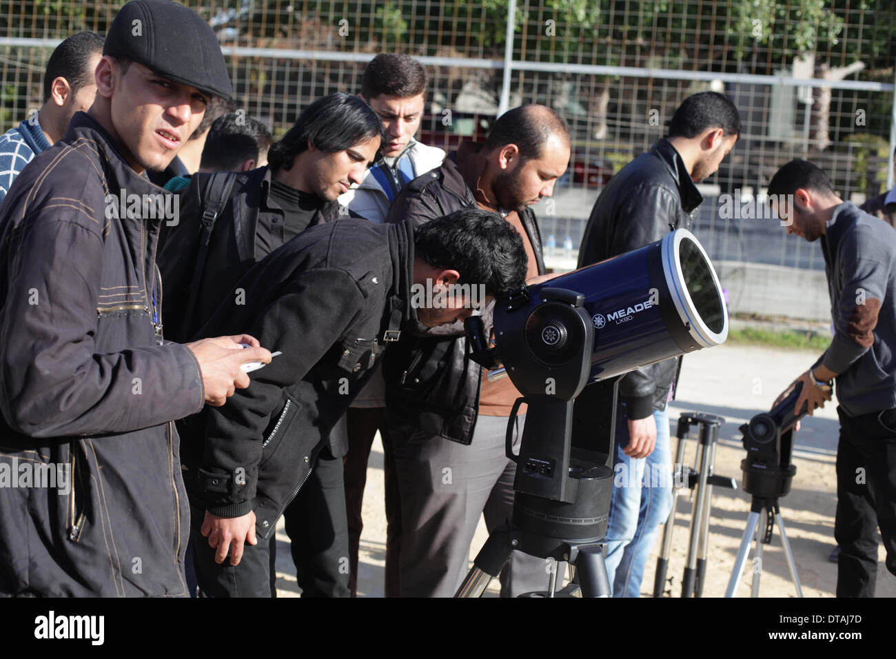 La ville de Gaza, bande de Gaza, territoire palestinien. Feb 13, 2014. Un étudiant palestinien regarde à travers un télescope vers le soleil au cours d'une formation pratique pour identifier l'astronome de taches de couleur et son impact, dans la ville de Gaza le 13 février 2014 Credit : Ashraf Amra/APA Images/ZUMAPRESS.com/Alamy Live News Banque D'Images