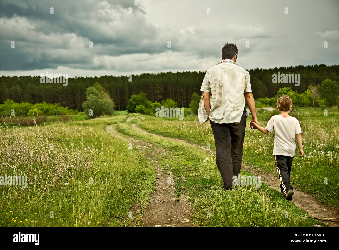 Garçon et son père sont sur la route, loin Banque D'Images