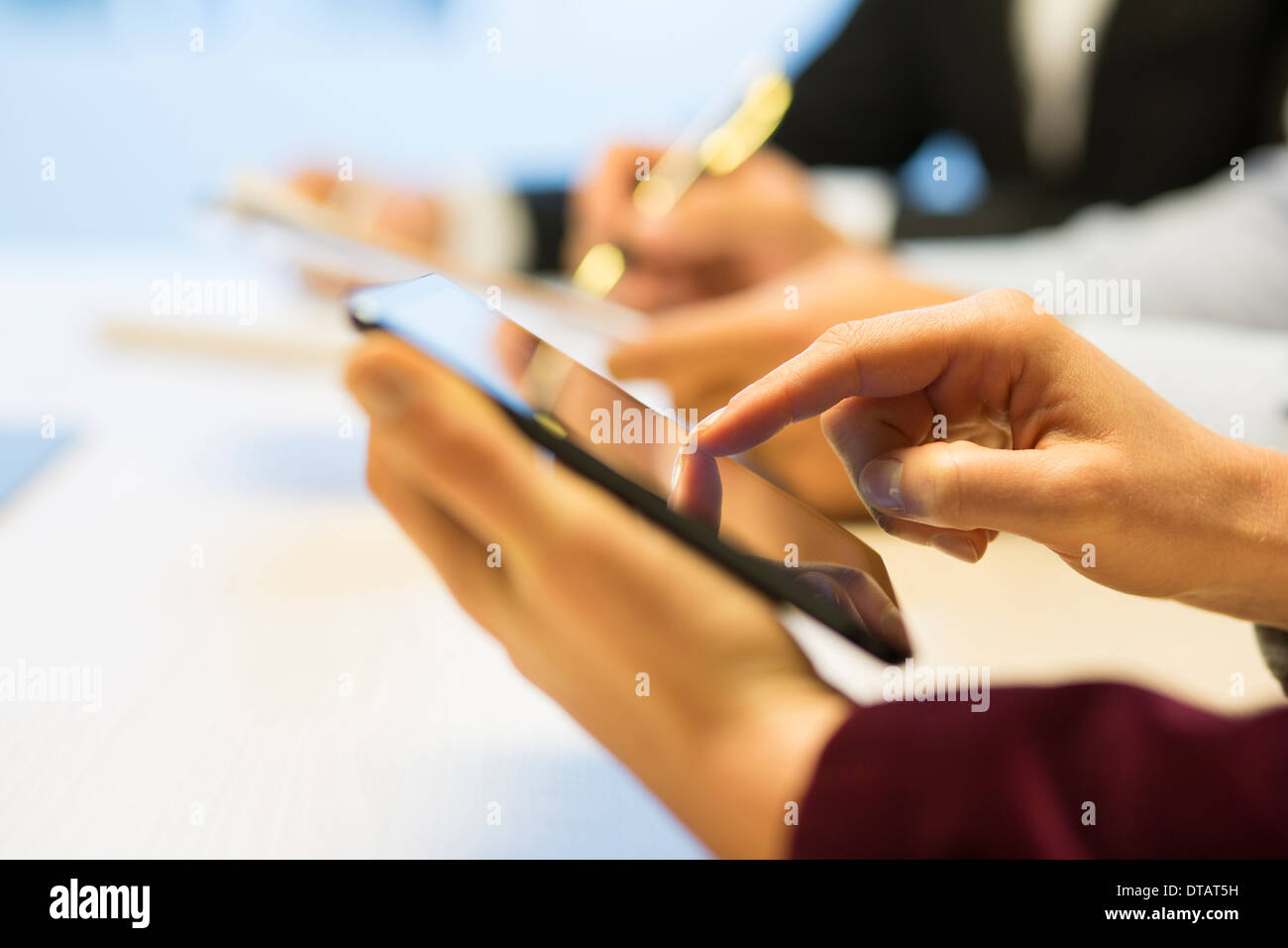 Close-up of Businesswoman mains écrit sur tablette numérique au cours d'une réunion Banque D'Images