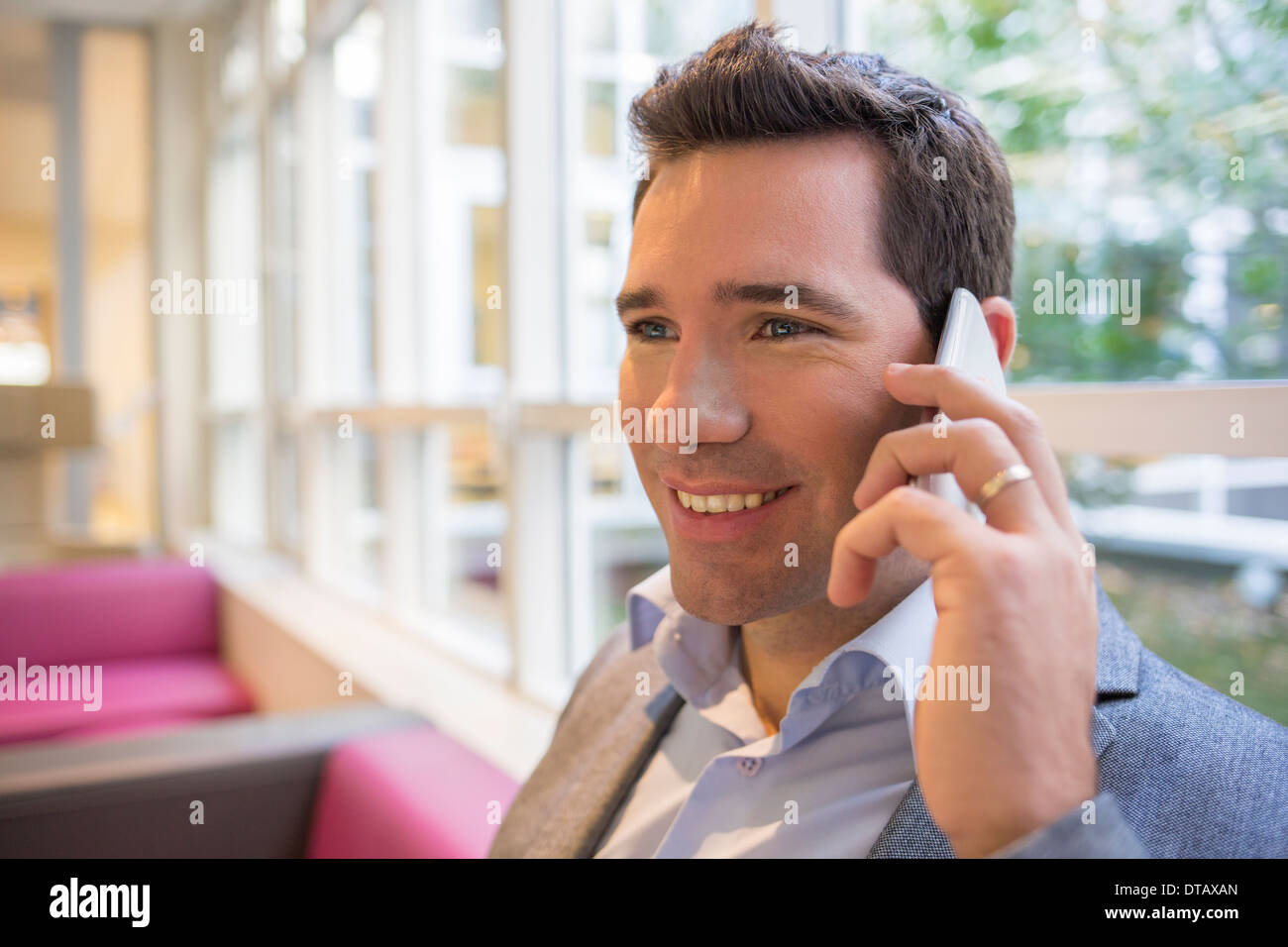 Happy smiling young woman on phone in office Banque D'Images