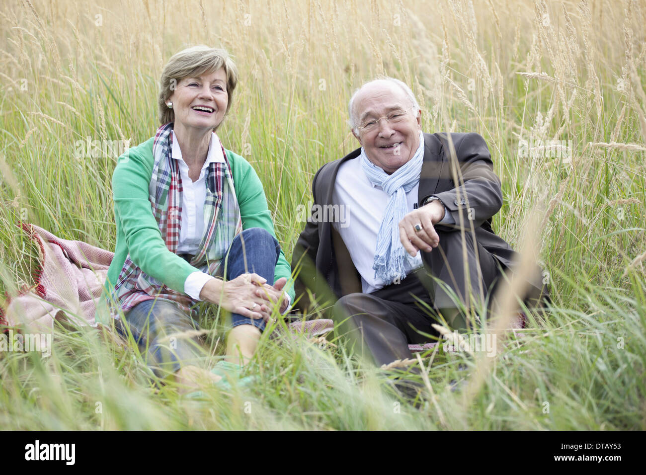 Couple sitting in field Banque D'Images