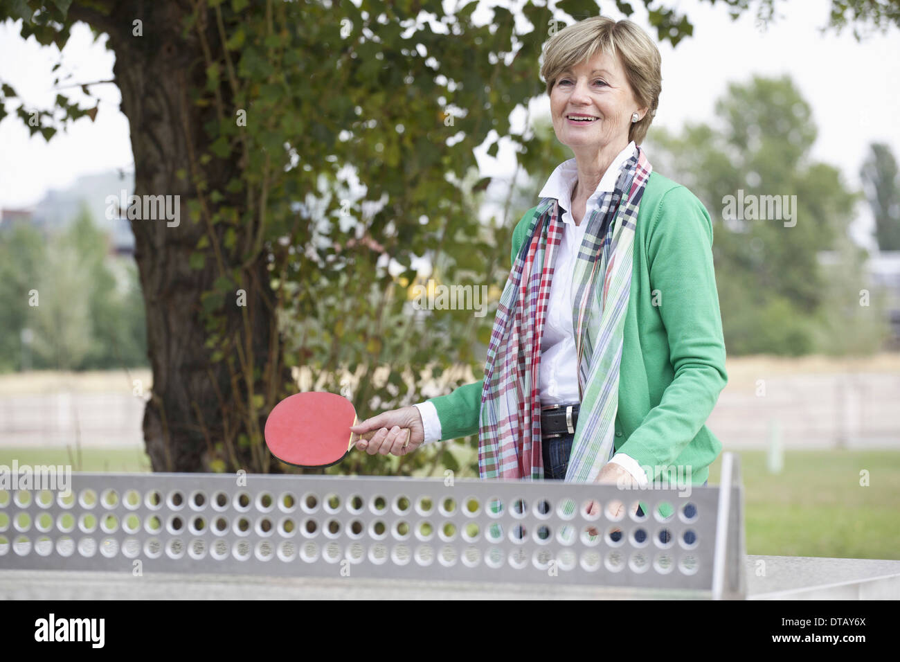 Femme mature à jouer au tennis de table Banque D'Images