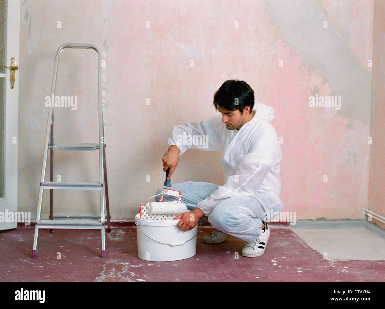 A man holding paint roller Banque D'Images