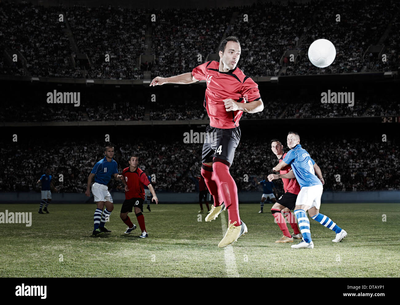 Soccer player jumping sur terrain Banque D'Images