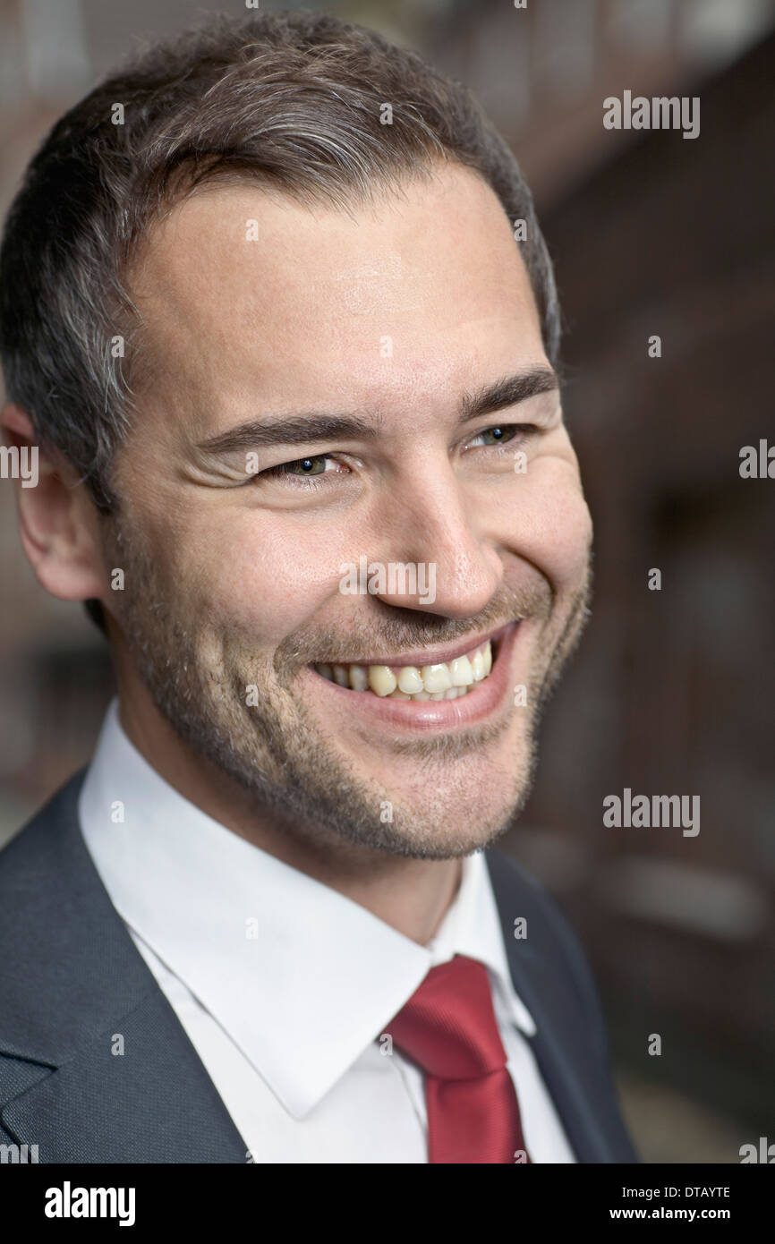 Mid adult man sitting and smiling, close-up Banque D'Images