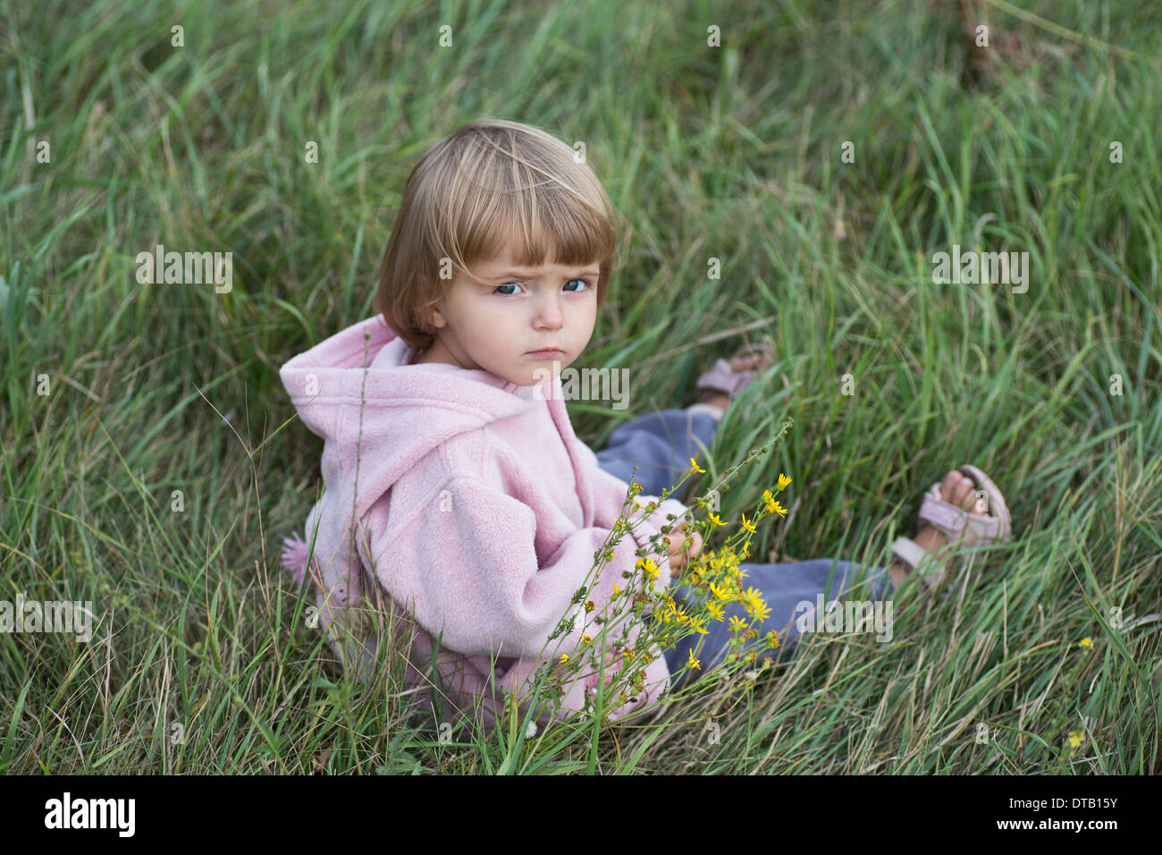 Girl sitting on grass, portrait Banque D'Images