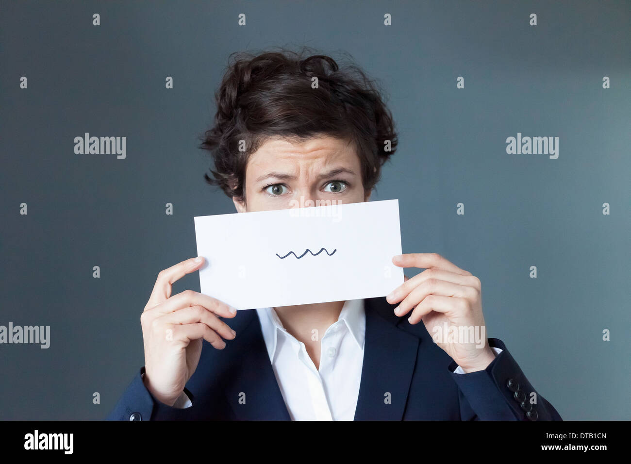 Une peur à la femme tenant le papier avec crayon Squiggle sign Banque D'Images