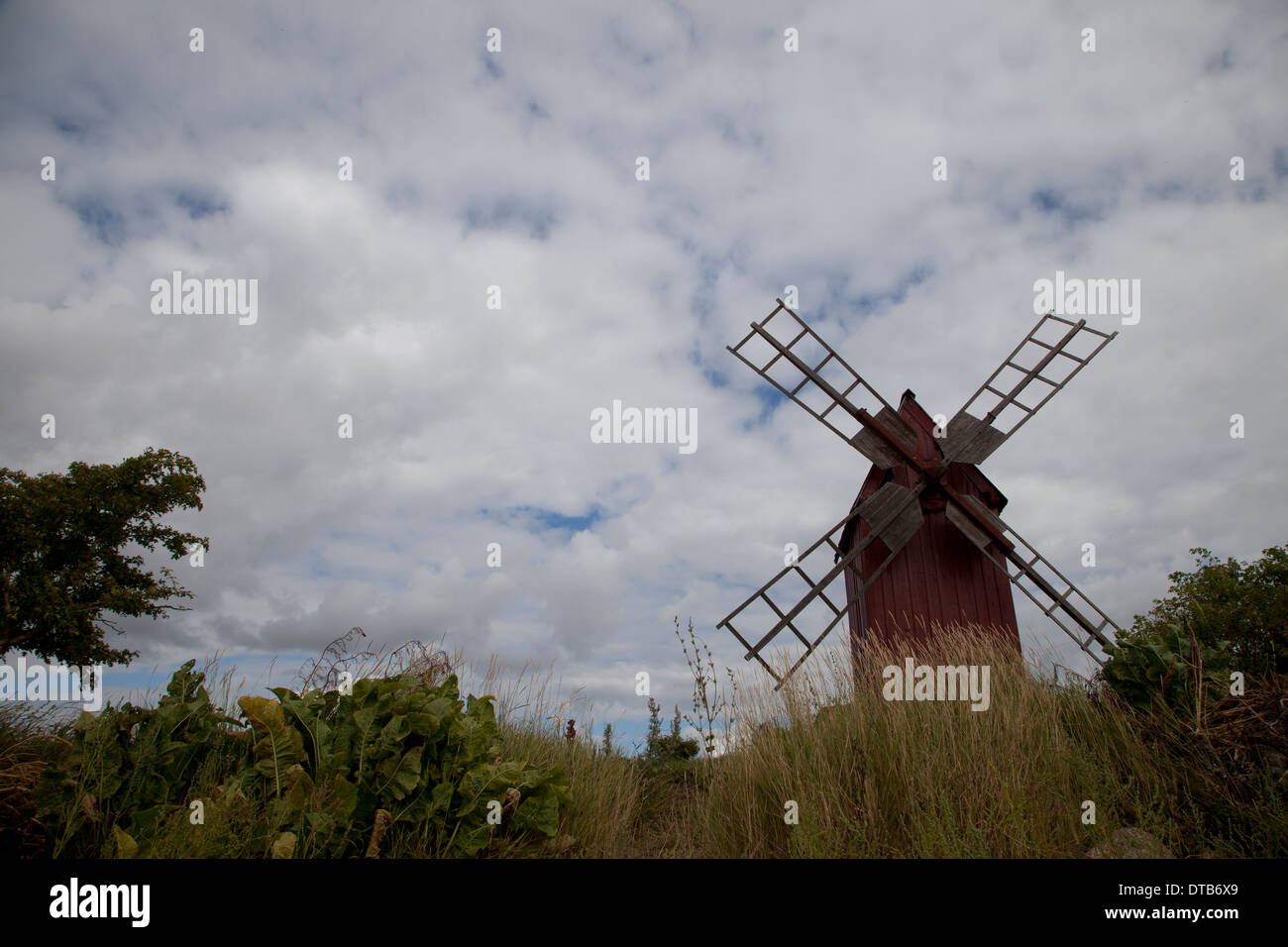 Ancien moulin à vent et de pelouse contre ciel nuageux, Oland, Sweden Banque D'Images
