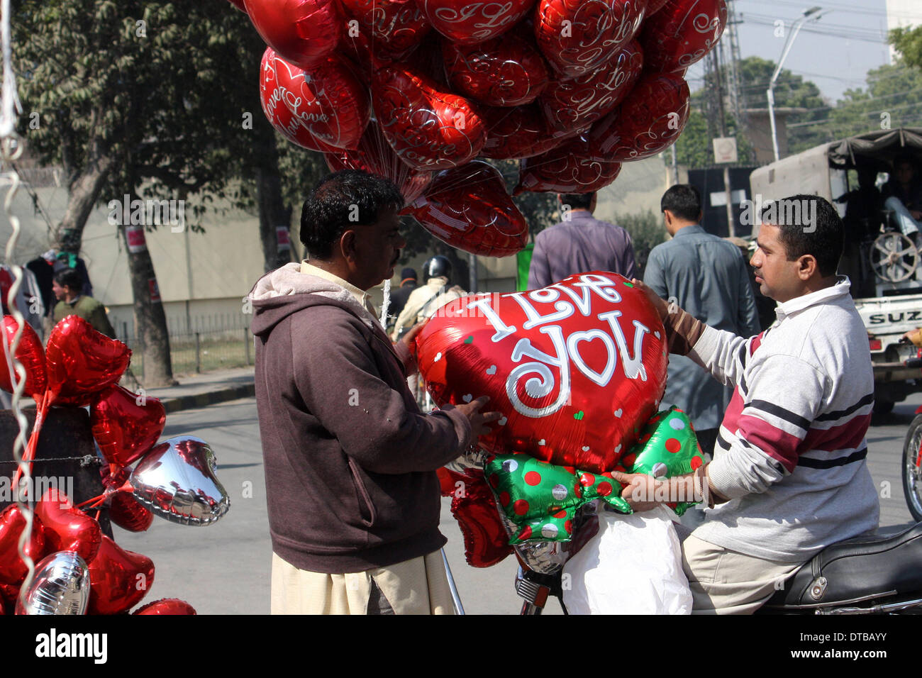Lahore, Pakistan. Feb 14, 2014. Un homme achète des ballons en forme de cœur sur la Saint-Valentin à Lahore, au Pakistan, le 14 février 2014. La Saint-Valentin est de plus en plus populaire parmi les jeunes Pakistanais, dont beaucoup ont pris les coutumes de donner les cartes, des chocolats et des cadeaux à leurs fiancées pour célébrer l'occasion. Credit : Jamil Ahmed/Xinhua/Alamy Live News Banque D'Images