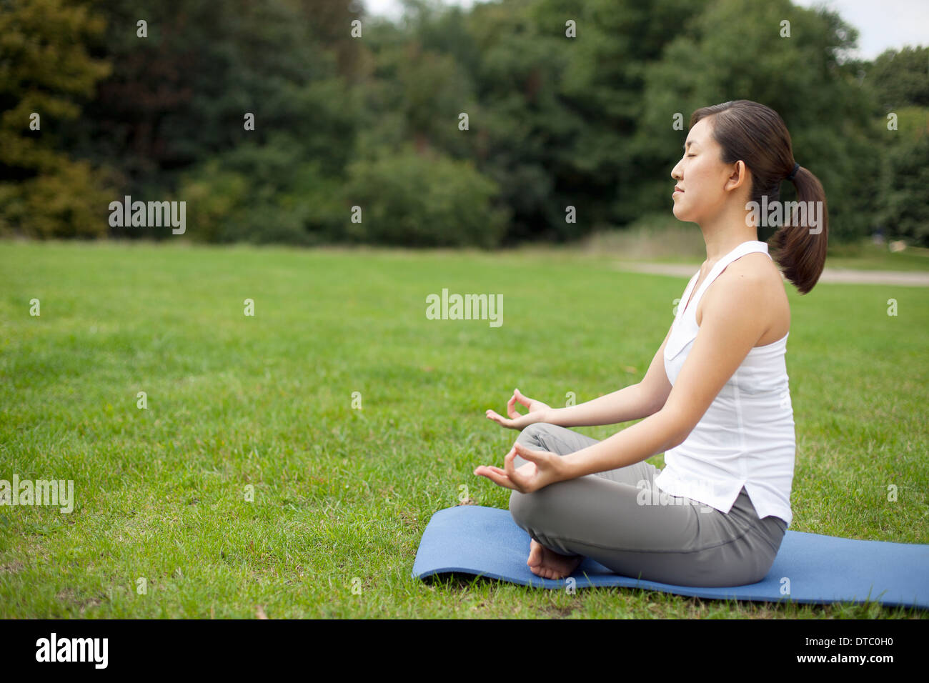 Jeune femme dans la pratique du yoga position du lotus park Banque D'Images
