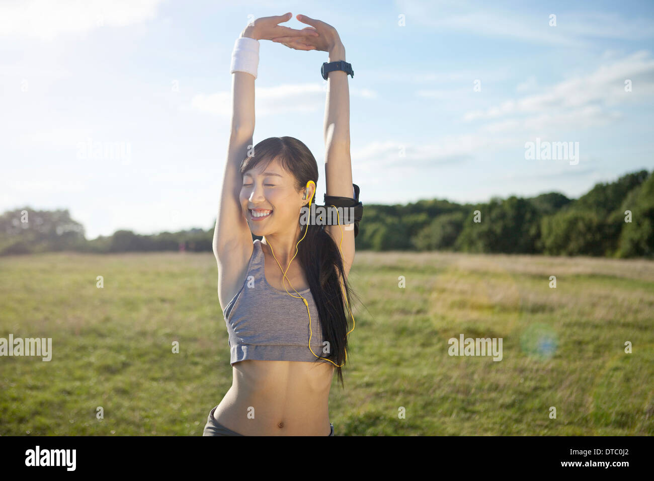 Young female runner stretching arms et l'échauffement Banque D'Images