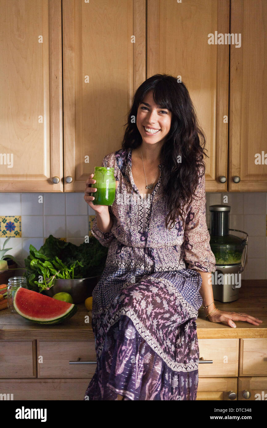 Jeune femme en cuisine avec du jus de légumes Banque D'Images