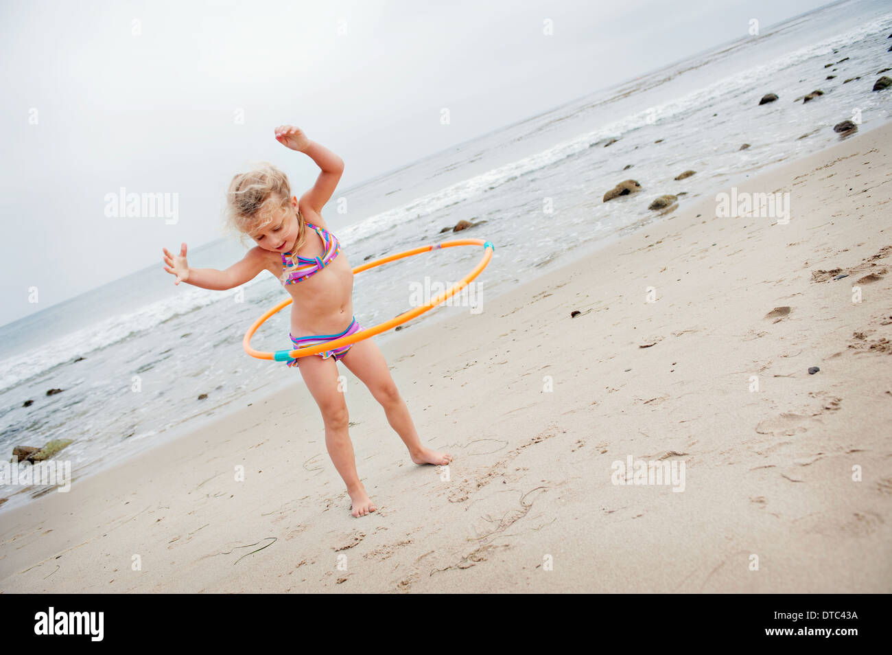 Jeune fille avec hoolahoop sur la plage Banque D'Images