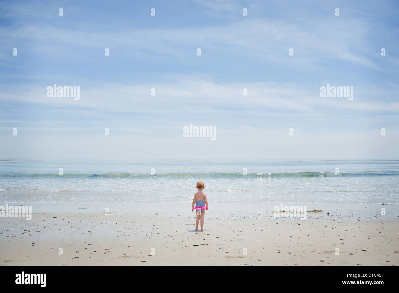 Appréhensif female toddler regardant la mer Banque D'Images