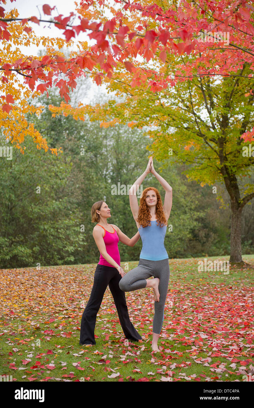 Professeur de Yoga l'enseignement aux jeunes femme en forêt Banque D'Images
