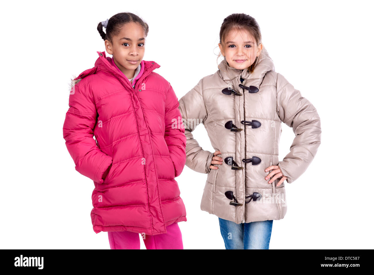 Les Jeunes filles posant dans des manteaux d'hiver isolé dans White Banque D'Images