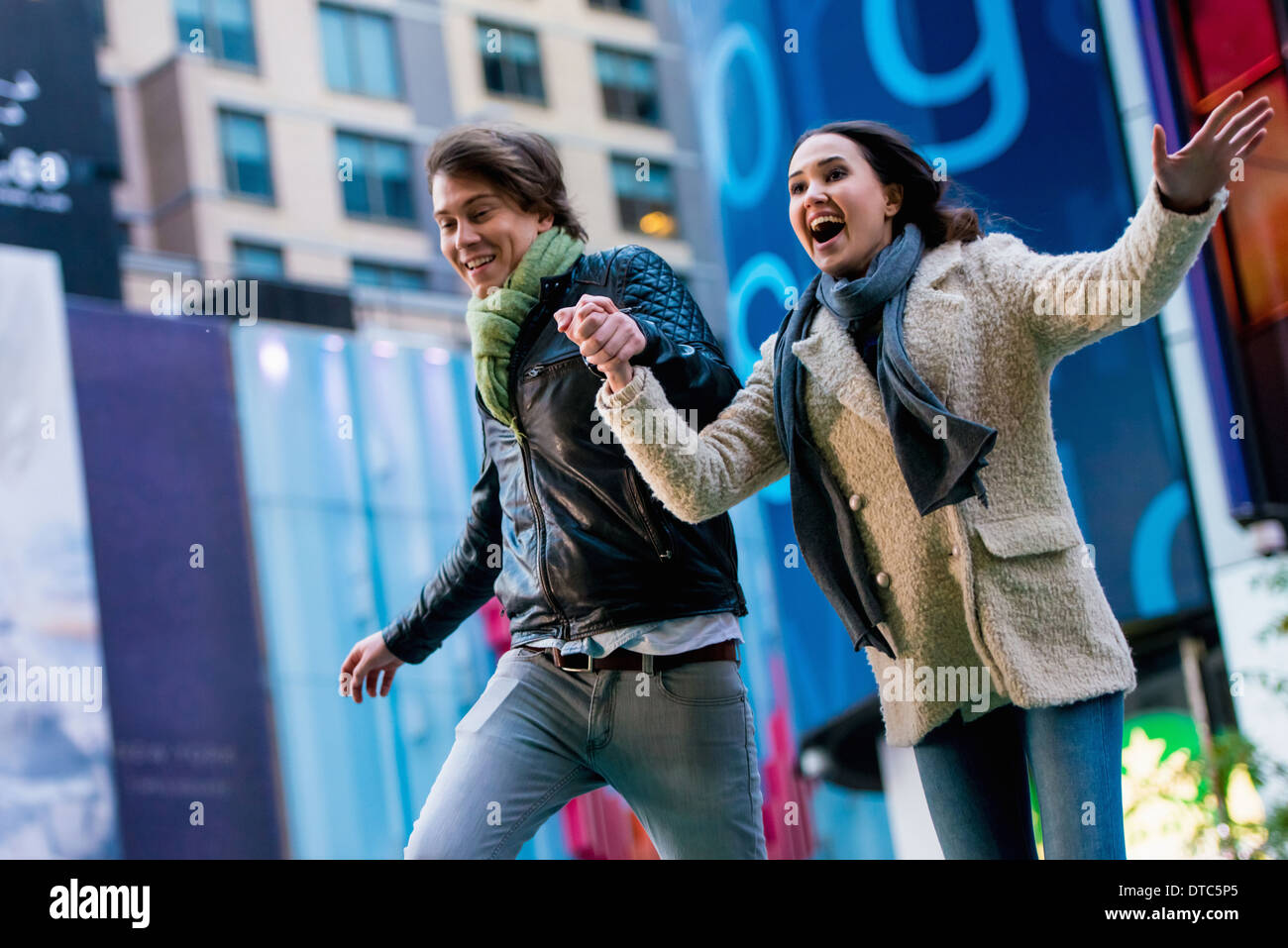 Jeune couple d'exécution sur street, New York City, USA Banque D'Images