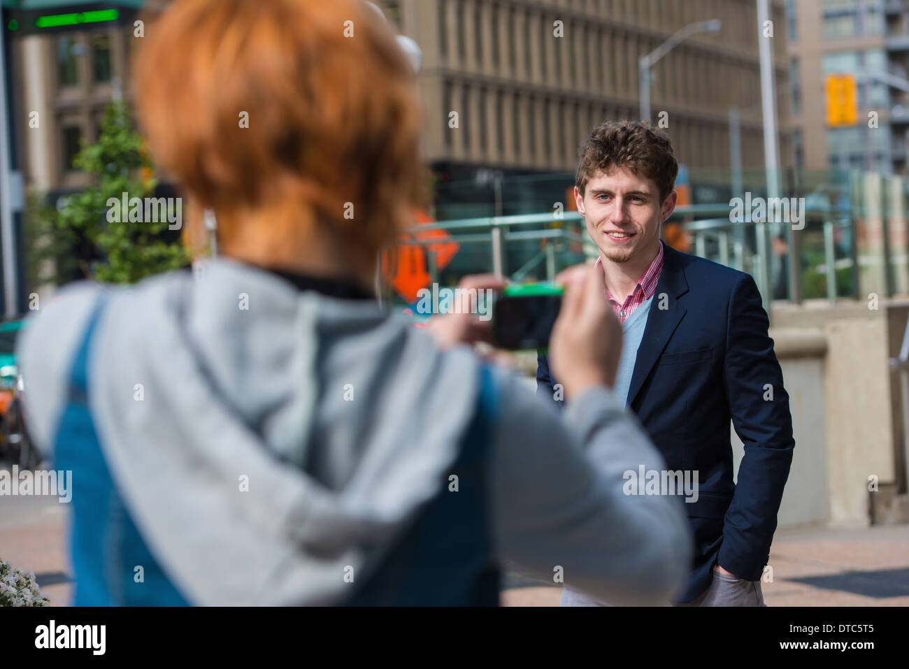 Young woman photographing boyfriend Banque D'Images
